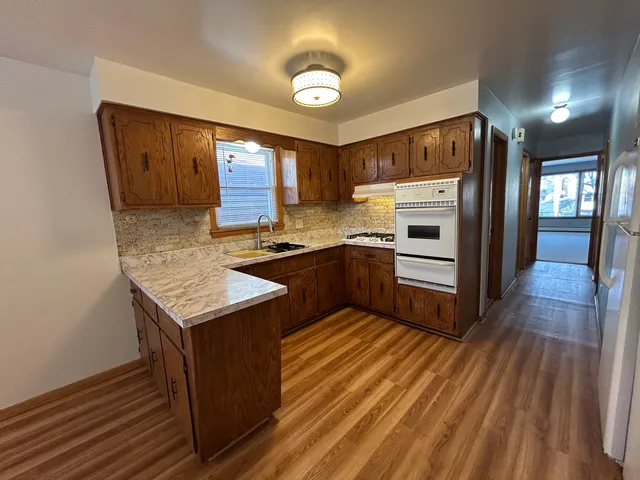 a kitchen with stainless steel appliances granite countertop a stove a sink and a refrigerator