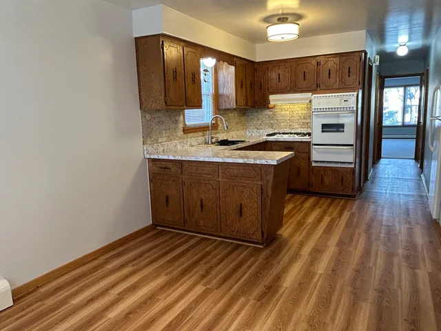 a kitchen with wooden floors and sink