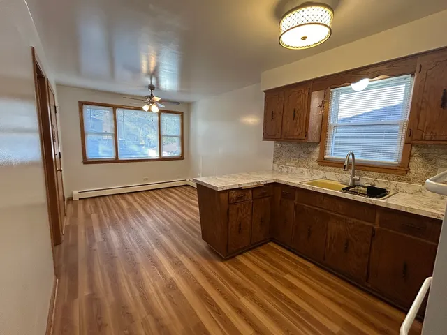 a kitchen with wooden cabinets and window