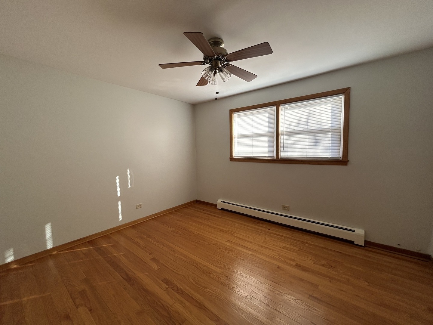 5350 North Central Avenue, Unit 1 Chicago, IL 60630 - Photo 8 of 24 an empty room with wooden floor chandelier fan and windows