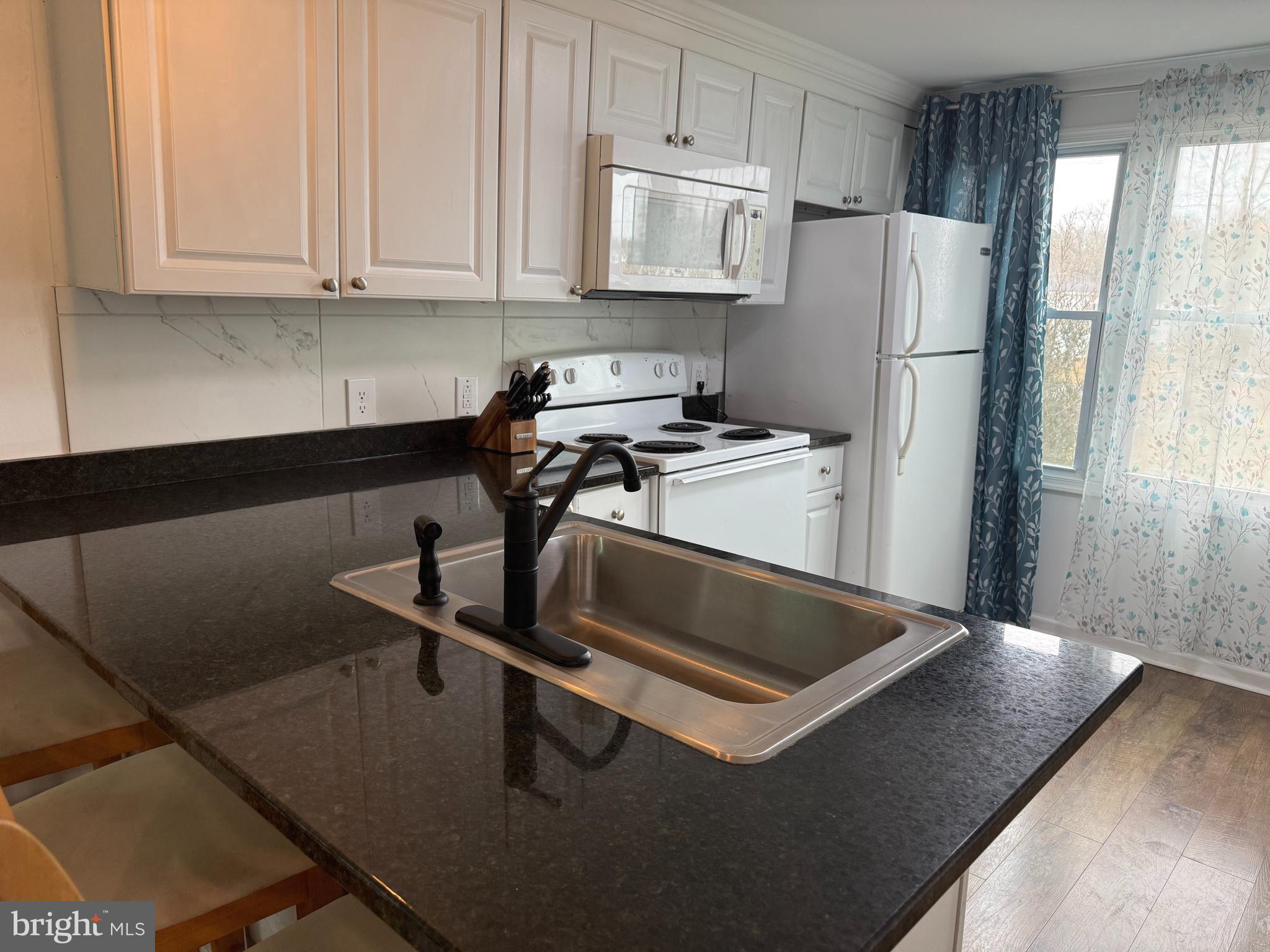 33987 Sunflower Road, Unit 3831 Lewes, DE 19958 - Photo 9 of 17 a kitchen with a refrigerator and a stove top oven