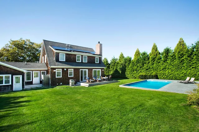 a view of a house with a big yard and potted plants