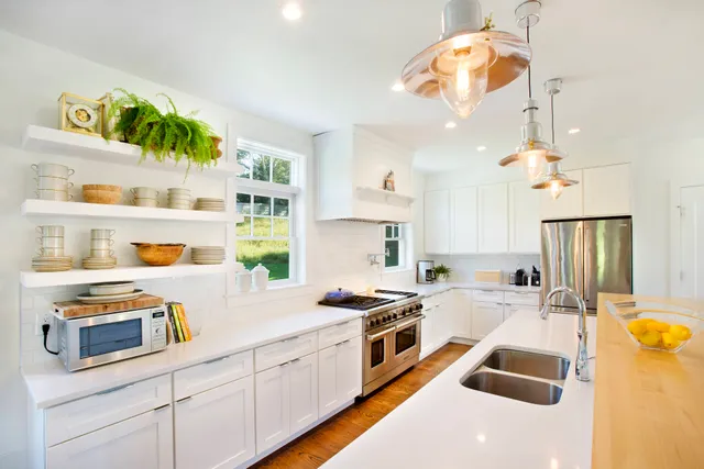 a kitchen with stainless steel appliances granite countertop a stove a sink and a white cabinets