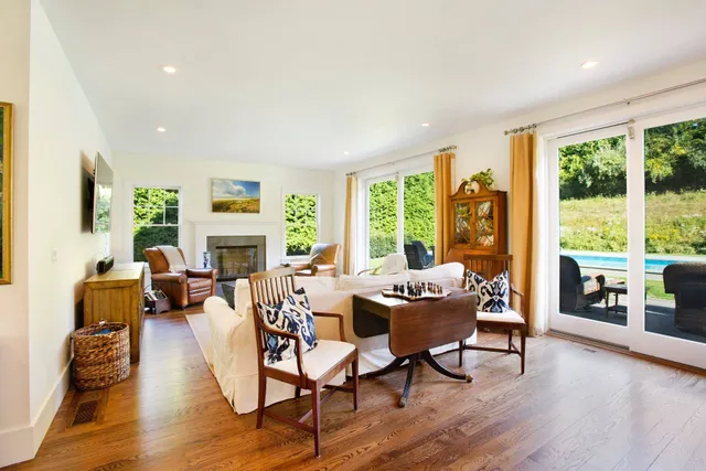 a living room with fireplace furniture and a large window