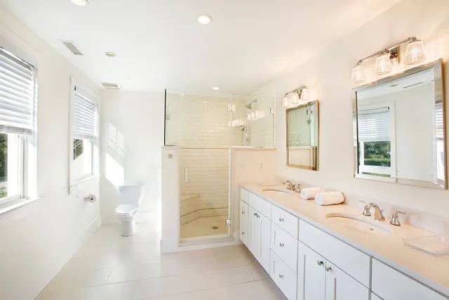 a spacious bathroom with a double vanity sink a mirror and a shower