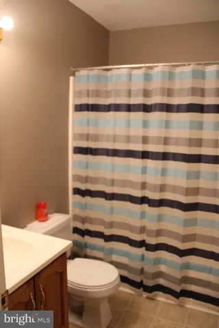 a bathroom with a granite countertop toilet and a sink