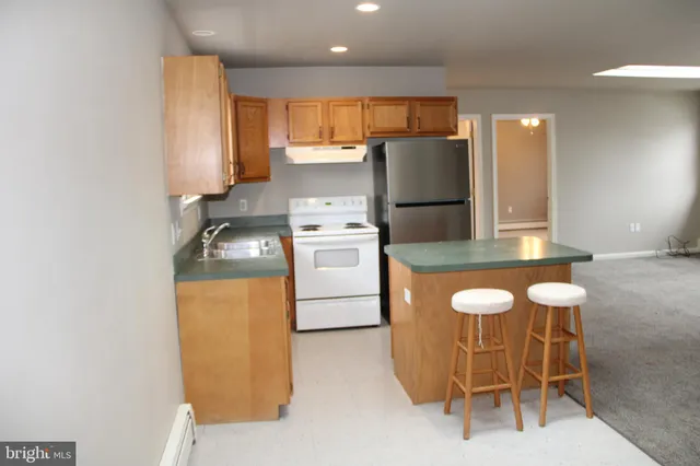 a kitchen with a sink a stove a refrigerator and blue cabinets