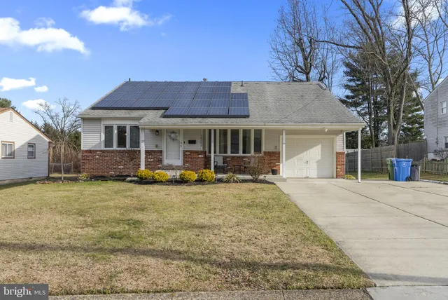 a front view of a house with a garden and yard