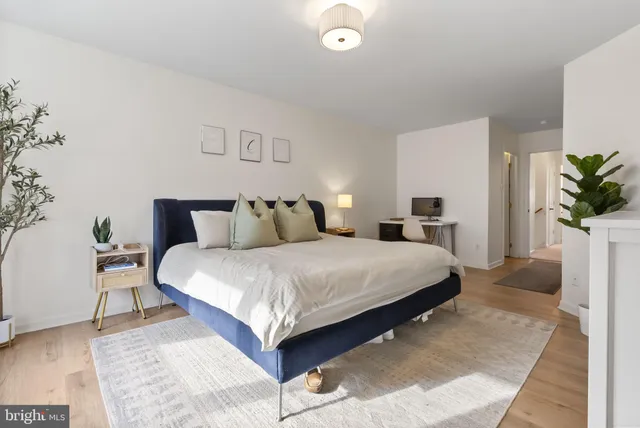 a bedroom with a bed and a potted plant