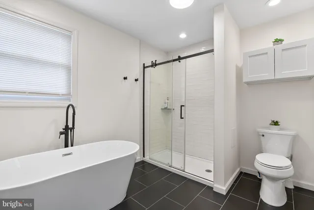 a bathroom with a toilet a sink and shower