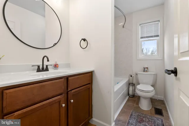 a bathroom with a toilet a sink and a mirror