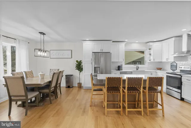a dining room with furniture a chandelier and wooden floor