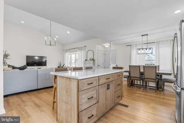 a kitchen with kitchen island white cabinets and stainless steel appliances
