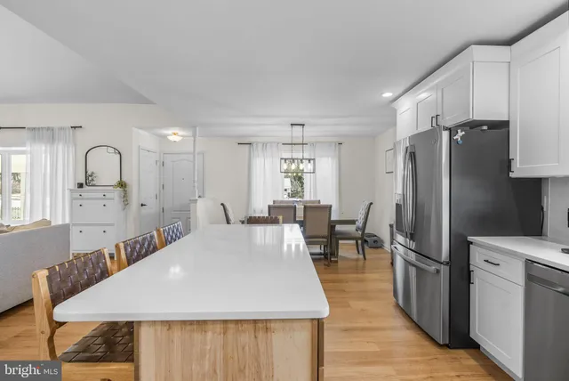 a large kitchen with sink a refrigerator and wooden floor