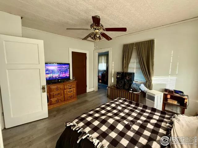 a bedroom with furniture a flat screen tv and a chandelier