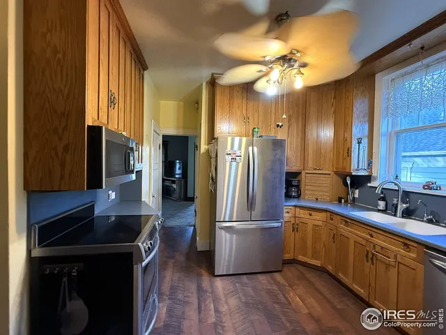 a kitchen with stainless steel appliances a sink cabinets and a wooden floor