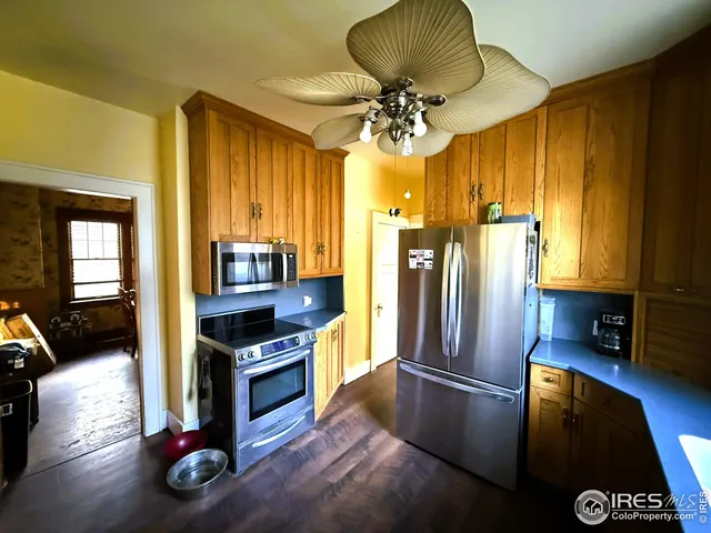 a kitchen with a refrigerator wooden floor and a chandelier