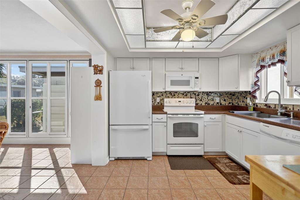 14 Strathmore Boulevard, Unit 14 Sarasota, FL 34233 - Photo 12 of 42 a kitchen with a stove a refrigerator and a sink