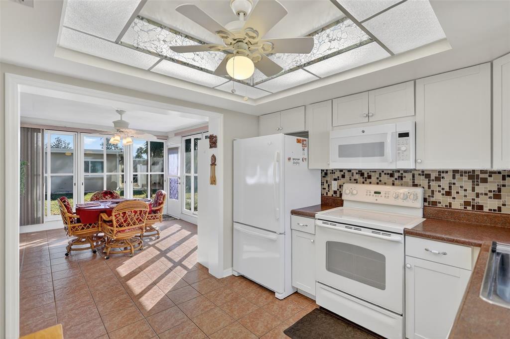 14 Strathmore Boulevard, Unit 14 Sarasota, FL 34233 - Photo 15 of 42 a kitchen with stainless steel appliances a stove a refrigerator and white cabinets