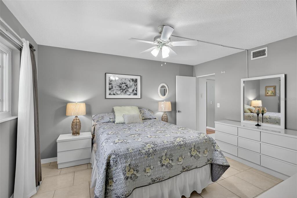 14 Strathmore Boulevard, Unit 14 Sarasota, FL 34233 - Photo 19 of 42 a bedroom with a bed and a chandelier