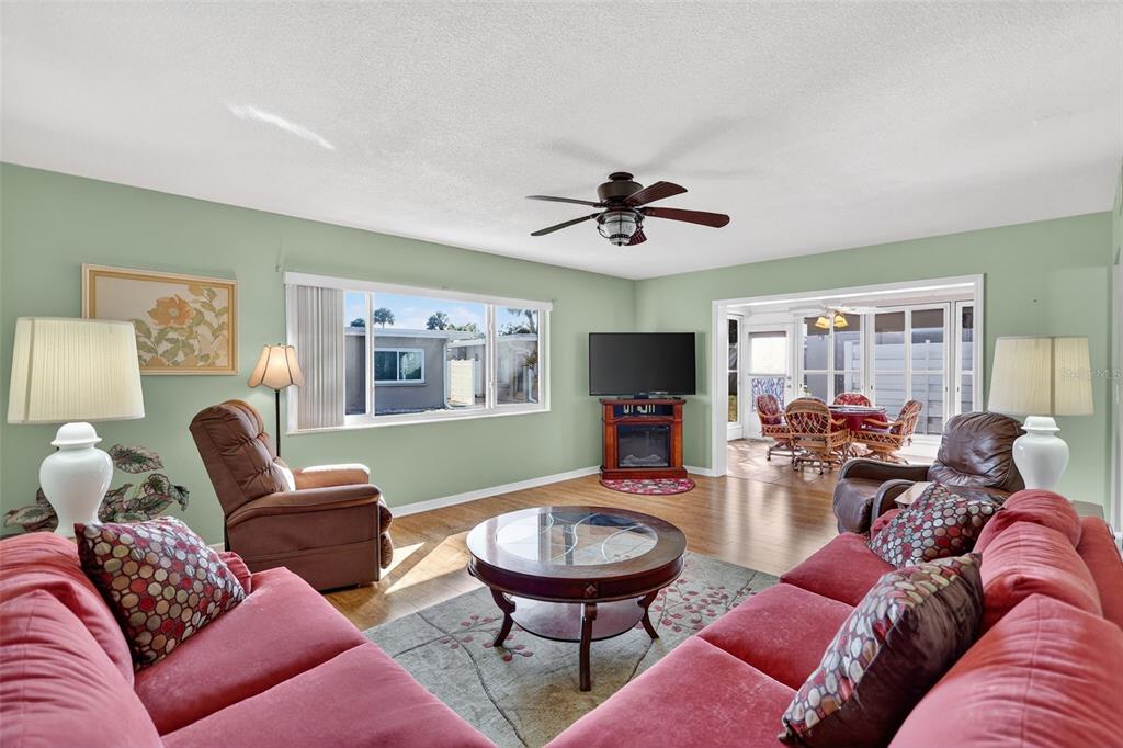 14 Strathmore Boulevard, Unit 14 Sarasota, FL 34233 - Photo 7 of 42 a living room with furniture a flat screen tv and a large window