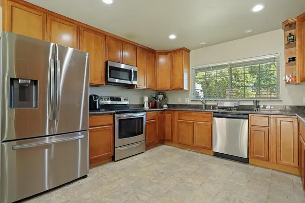 a kitchen with stainless steel appliances granite countertop a sink and cabinets