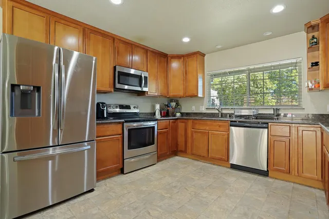 a kitchen with stainless steel appliances granite countertop a sink and cabinets