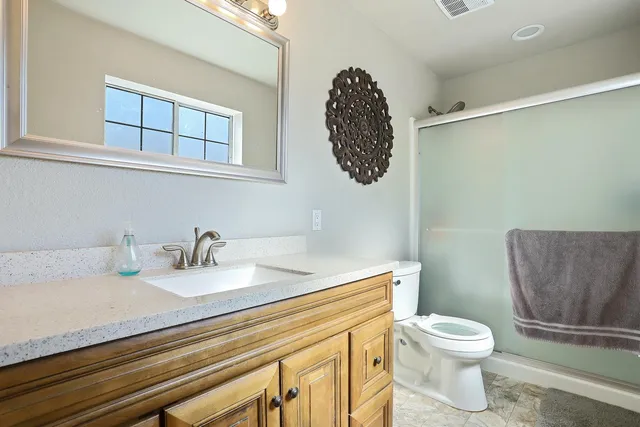 a bathroom with a toilet a sink and mirror
