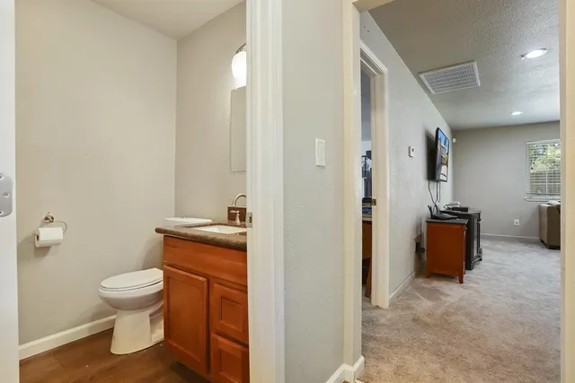 a bathroom with a granite countertop toilet sink and mirror