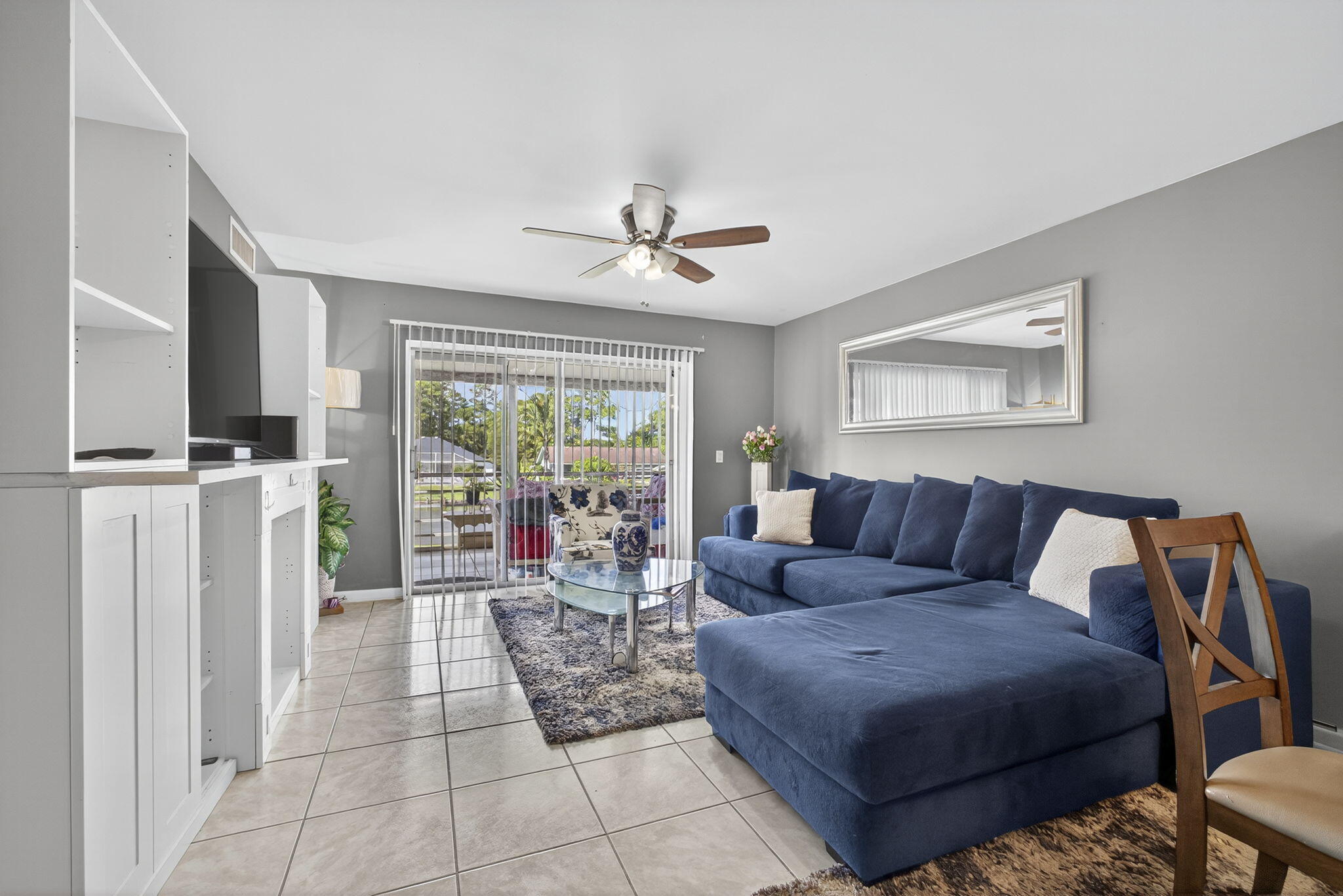 12001 Poinciana Boulevard, Unit 204 Royal Palm Beach, FL 33411 - Photo 19 of 42 a living room with furniture a flat screen tv and a ceiling fan