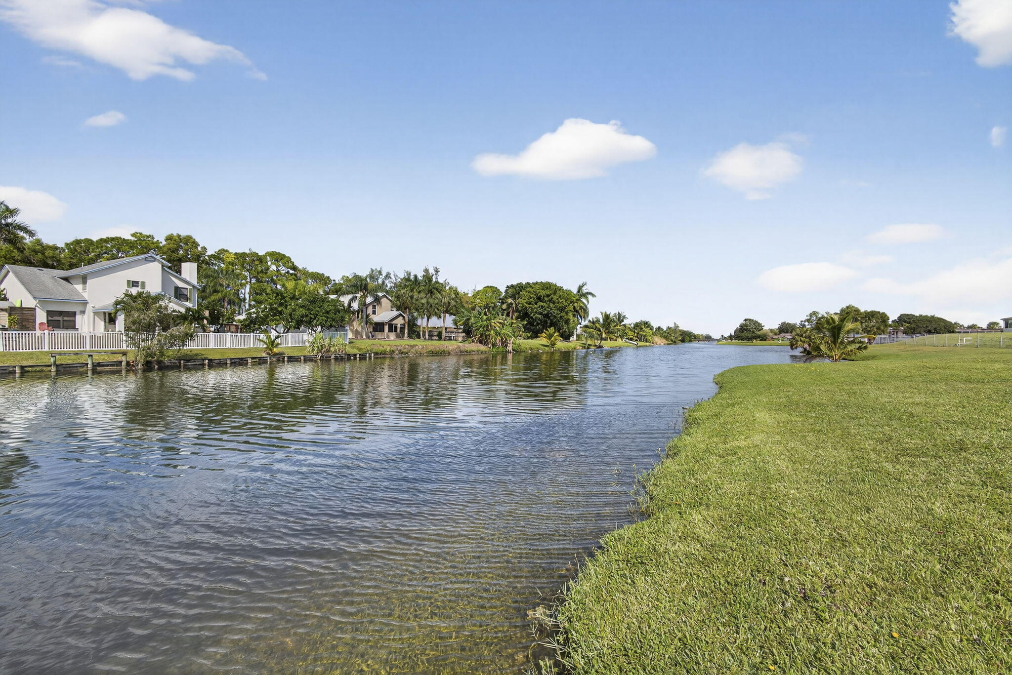 12001 Poinciana Boulevard, Unit 204 Royal Palm Beach, FL 33411 - Photo 5 of 42 a view of a lake with houses in the back