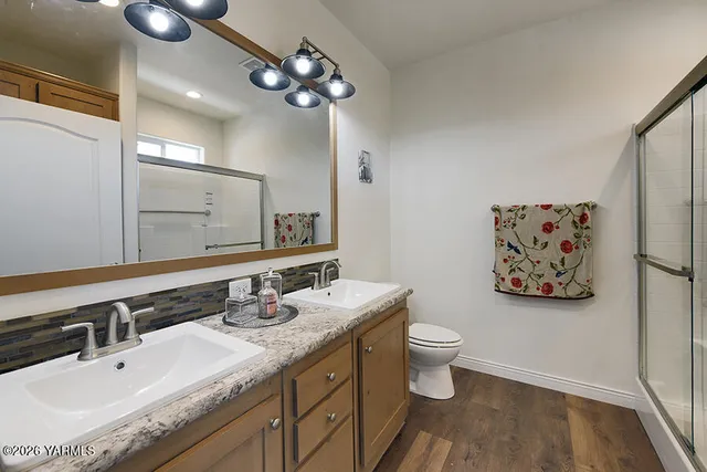 a bathroom with a granite countertop sink a toilet and a mirror