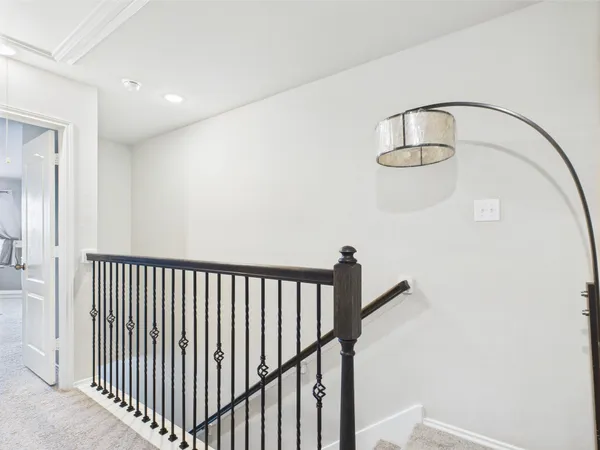 a view of staircase with railing and white walls
