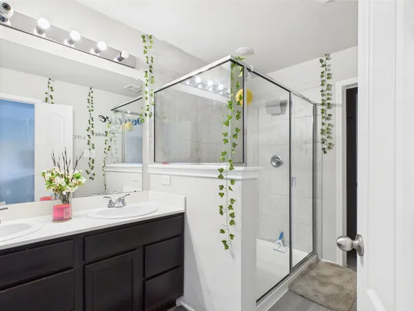 a bathroom with a shower sink and mirror