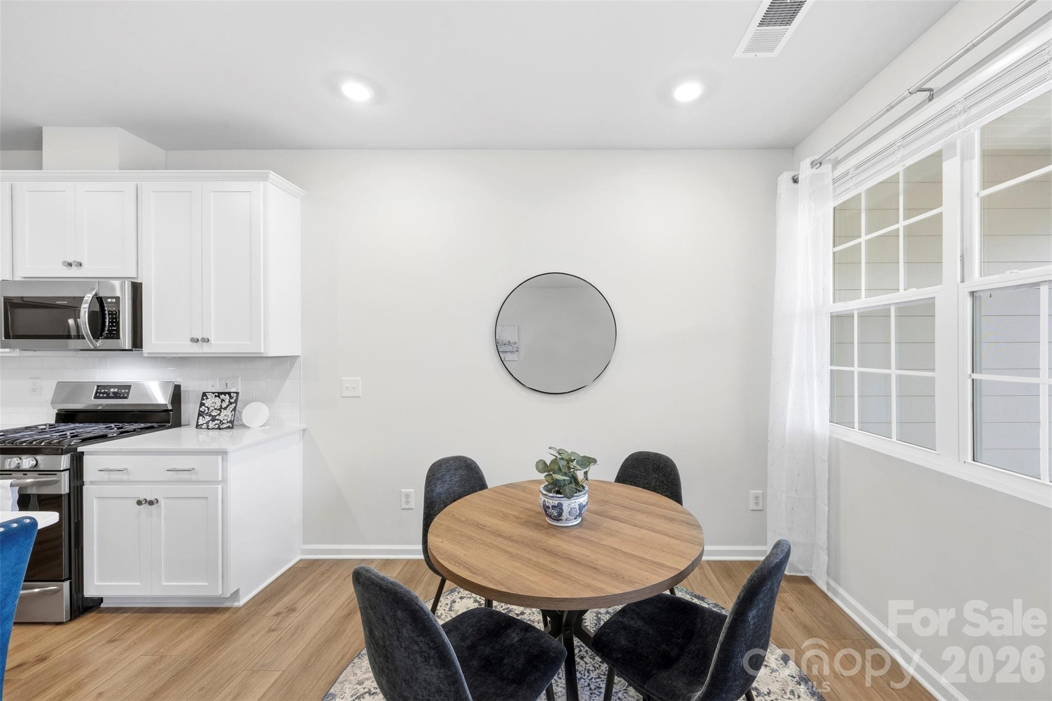 5030 Moss Pne Way Fort Mill, SC 29708 - Photo 14 of 28 a kitchen with a dining table chairs and white cabinets