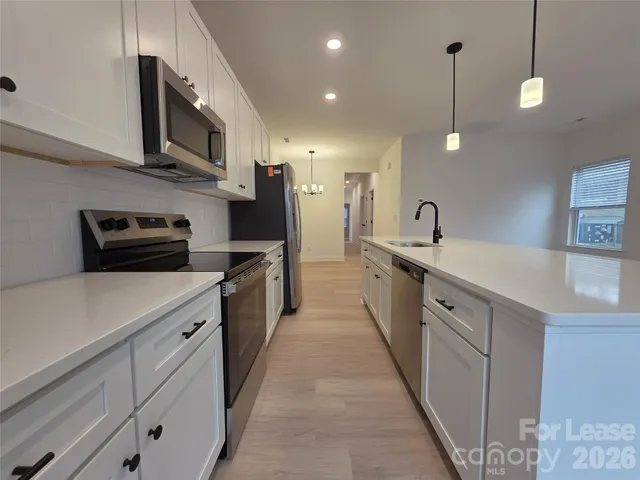 a large kitchen with stainless steel appliances lots of counter space and a sink