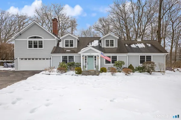 a front view of a house with a yard covered in snow