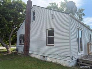 7588 Pelham Road Taylor, MI 48180 - Photo 5 of 20 Siding exterior with brick chimney, multiple windows, and a raised wooden deck
