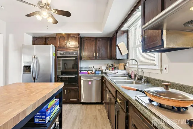 a kitchen with stainless steel appliances granite countertop a sink a stove and refrigerator
