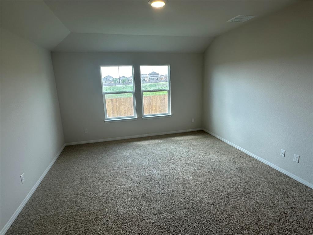563 Evergreen Sumac Loop Kyle, TX 78640 - Photo 9 of 18 A spacious room offers comfortable carpeting and windows for natural light.