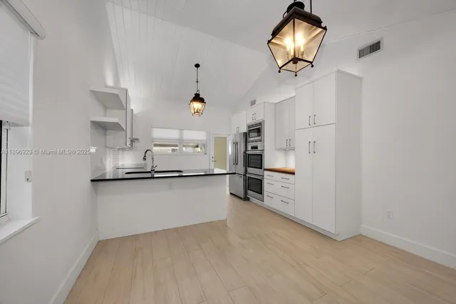 a kitchen with stainless steel appliances granite countertop a sink a stove and refrigerator