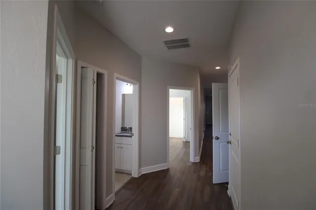a view of a hallway with wooden floor