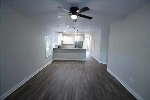 a view of a kitchen with wooden floor and a ceiling fan