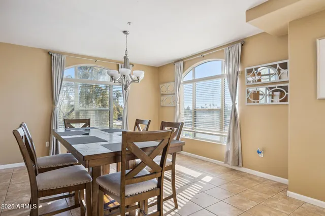 a dining room with furniture a chandelier and wooden floor