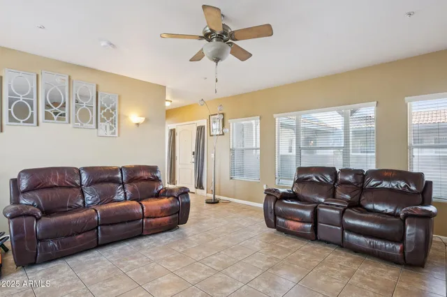 a living room with furniture ceiling fan and a window