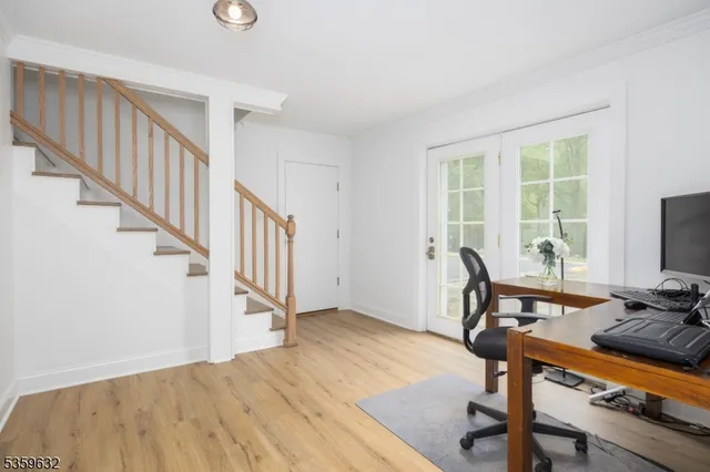 a view of a livingroom with wooden floor and furniture