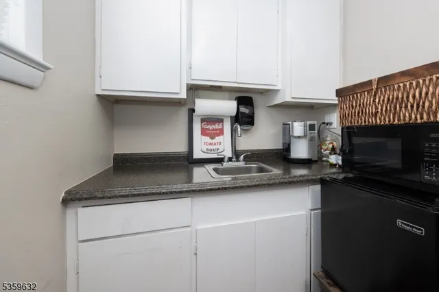 a kitchen with stainless steel appliances granite countertop a sink a stove and a microwave