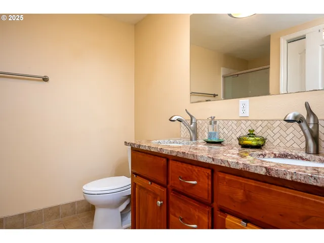 a bathroom with a granite countertop toilet and a sink