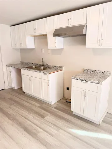 a kitchen with white cabinets and white appliances