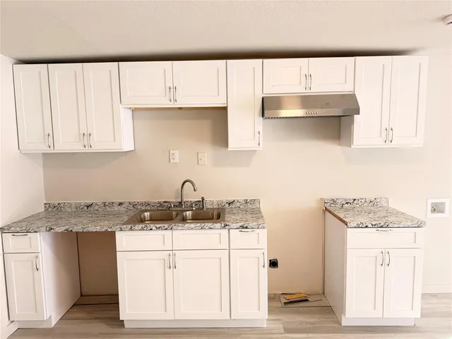 a kitchen with kitchen island granite countertop white cabinets and white appliances